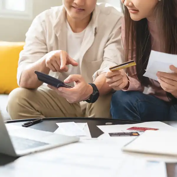 A young couple with a stack of bills and credit cards